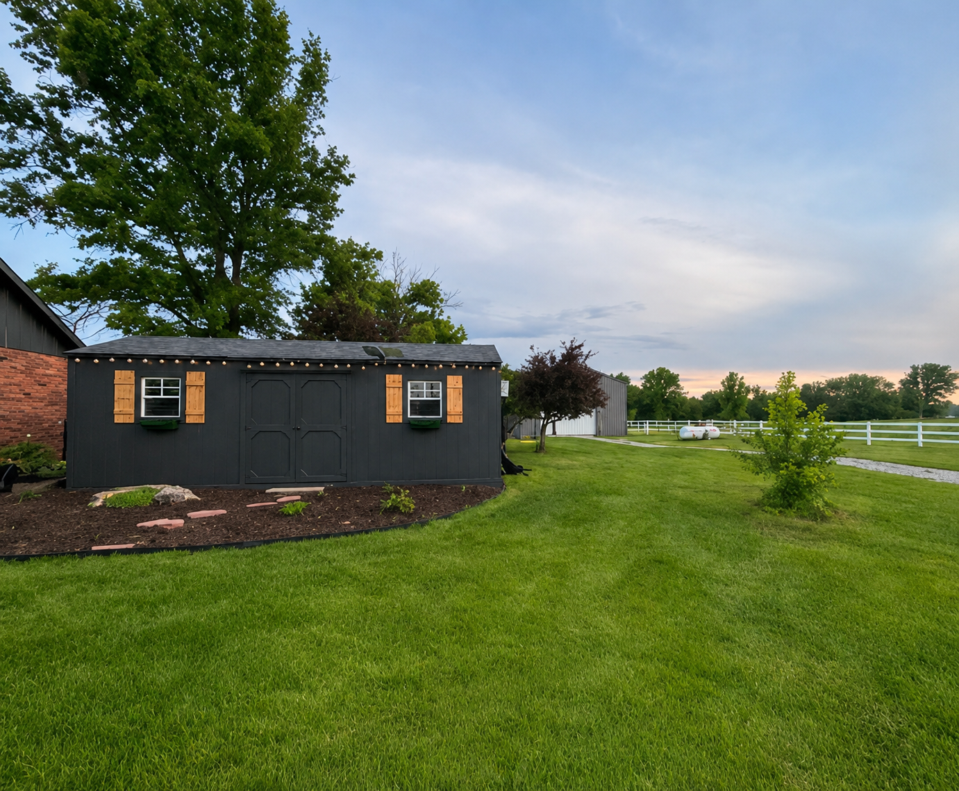 Exterior of Paws Retreat's private dog boarding facility in Holden, Missouri, with a fenced lawn and outdoor space.