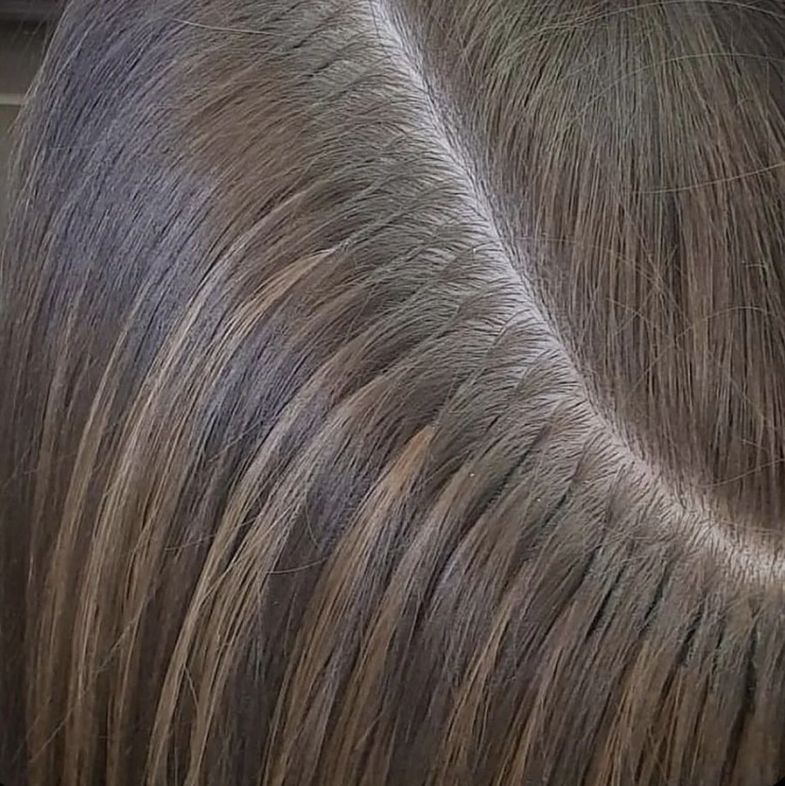 Close-up of brown and blonde hair with a visible scalp.