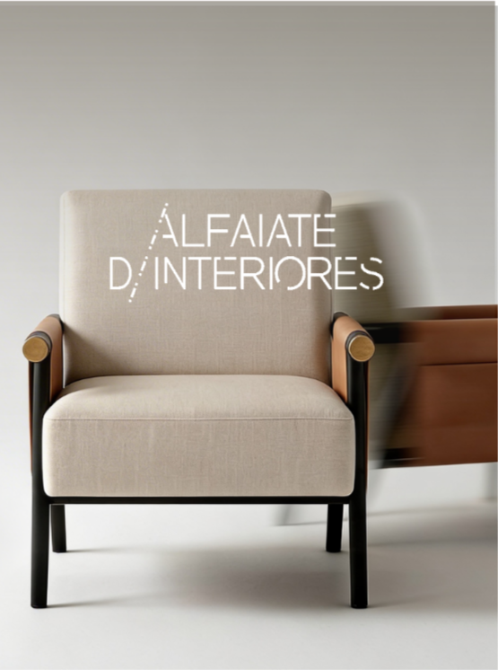 A beige armchair with black legs and wooden armrests, positioned in front of a plain wall. There is a blurred brown piece of furniture or object to the right of the chair. Text overlay says 'ALFAIATE D'INTERIORES'.