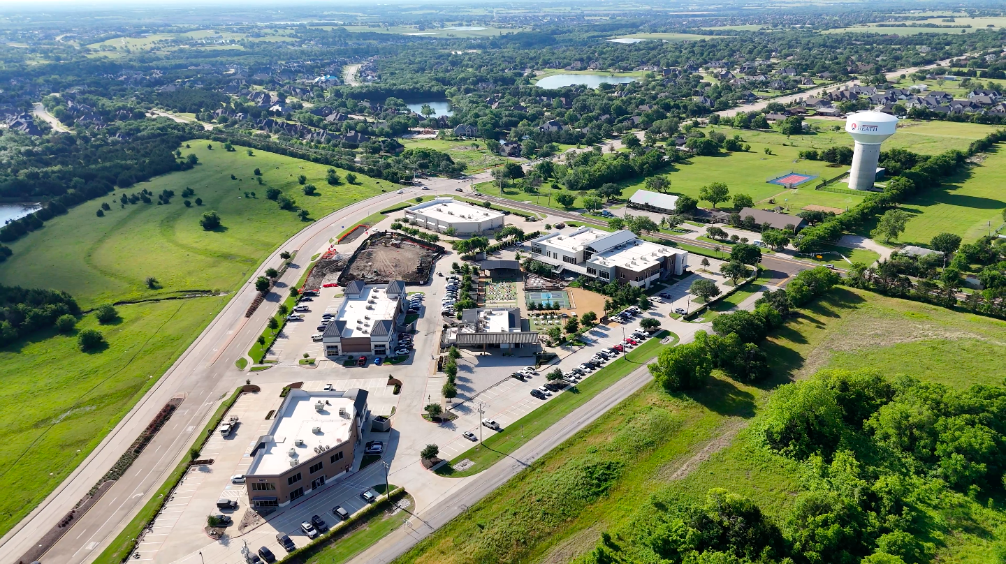 Aerial drone view of Heath, TX with the city water tower, shopping centers, and green space