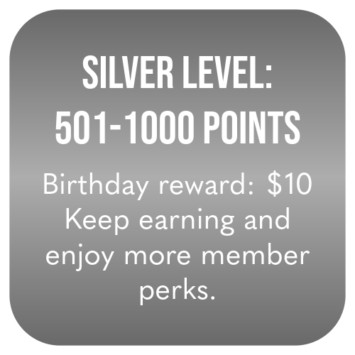 A gray sign displaying a rewards program with silver level benefits, including 501 to 1000 points, a $10 birthday reward, and perks for earning more points.