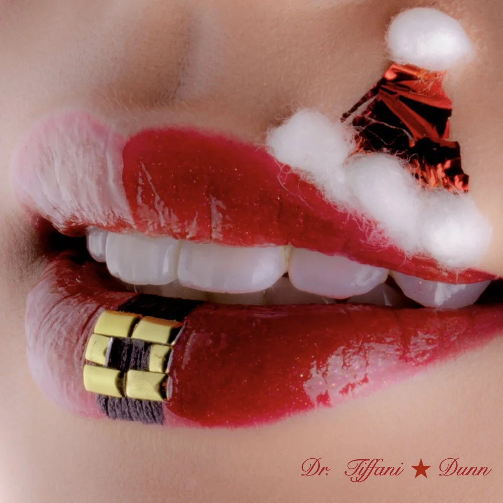 Close-up of lips with red lipstick, gold teeth, and cotton balls with eating foil on upper lip, with signature 'Dr. Tiffani Dunn' in the bottom right corner.