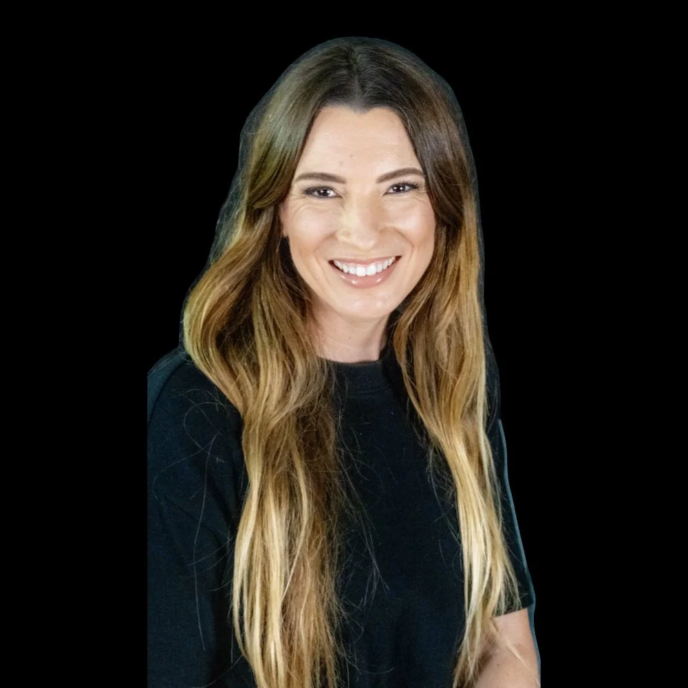 A woman with long, wavy brown hair, smiling, wearing a black shirt, against a black background.