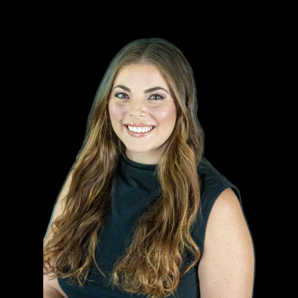A smiling woman with long wavy brown hair wearing a sleeveless black top against a black background.