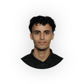 Portrait of a young man with curly black hair, wearing a black shirt, against a white background.