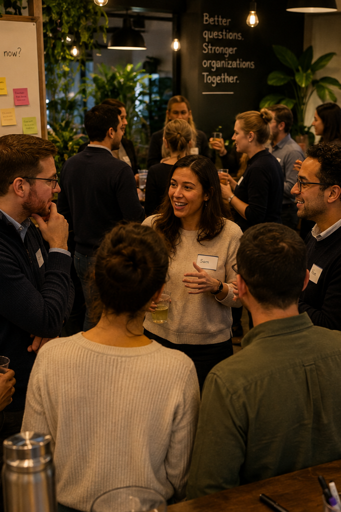 Group of people socializing and chatting at a networking event in an indoor space with plants and ambient lighting.