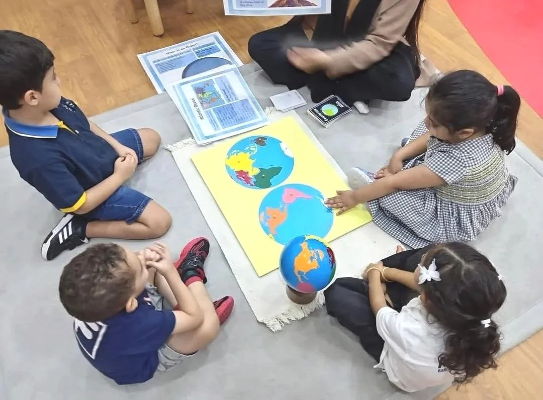 Children exploring Montessori globe activity at Al Fajr Nursery Dubai