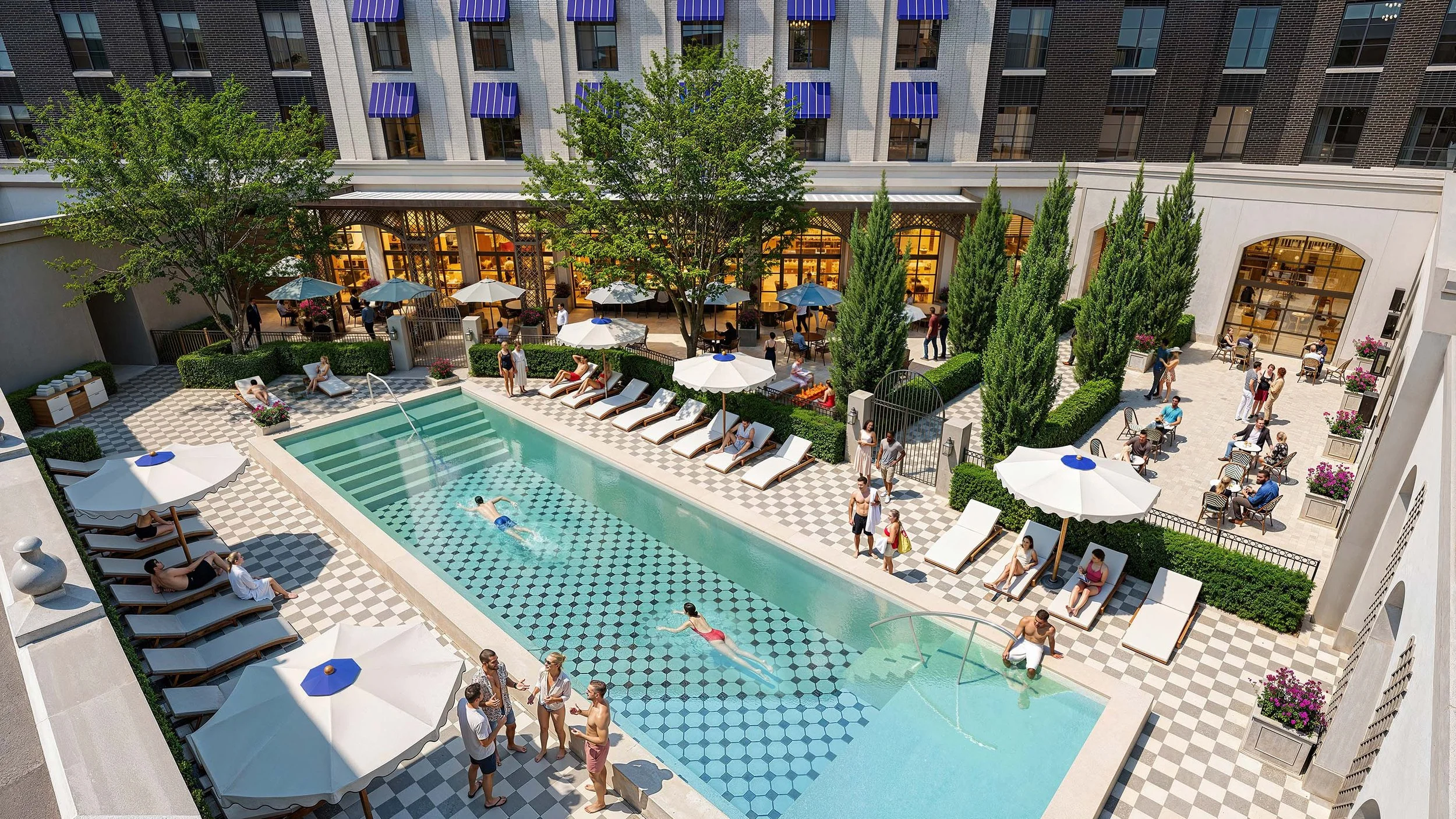 A hotel pool in a courtyard with cabana chairs and umbrellas