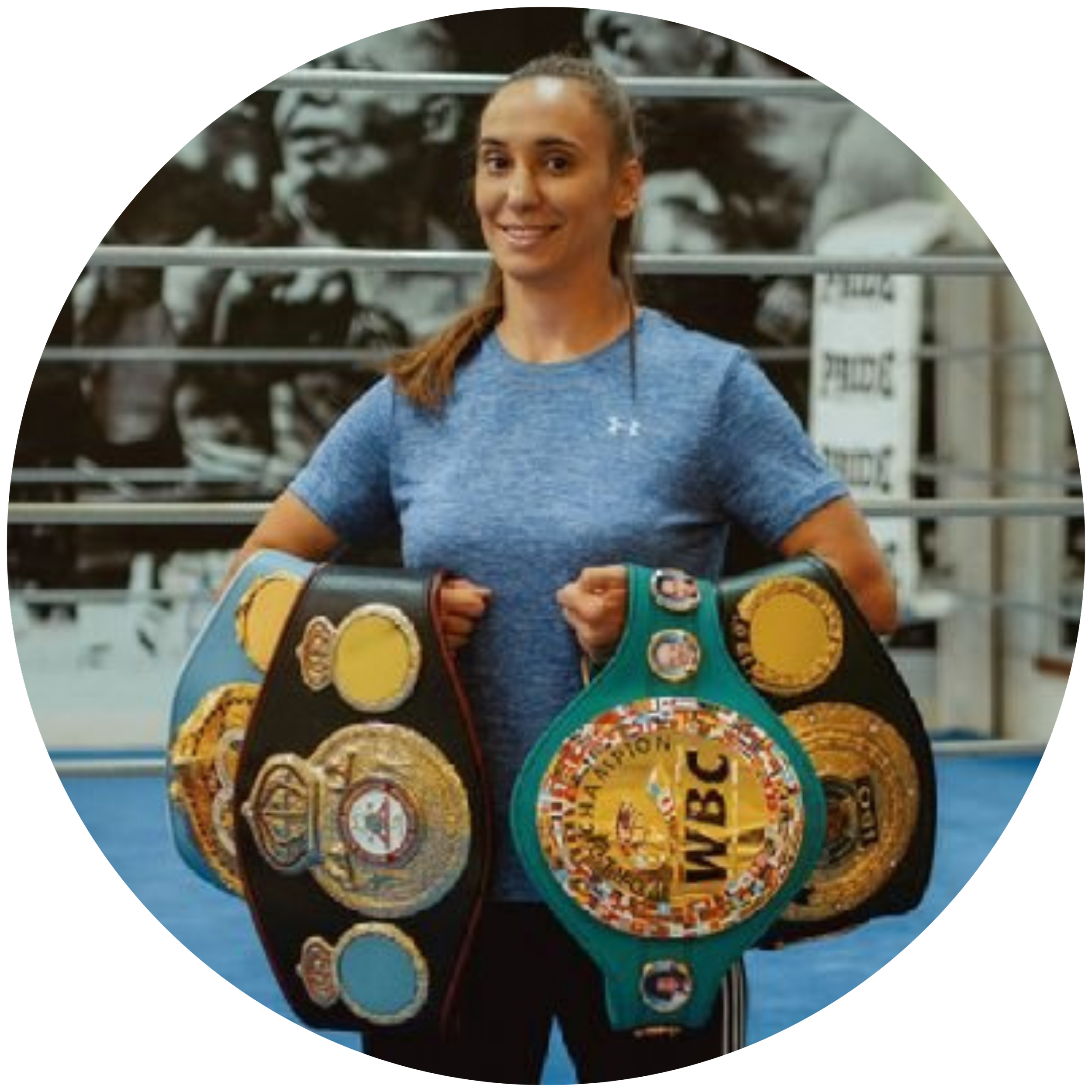 A woman in a ring holding 4 times world championships belts in boxing, testimonial to Martina Kikic, LinkedIn executive branding advisor