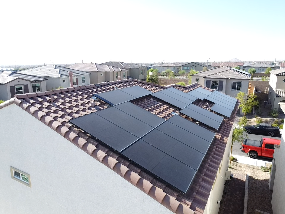 Residential rooftops with solar panels installed on the main house in a suburban neighborhood.