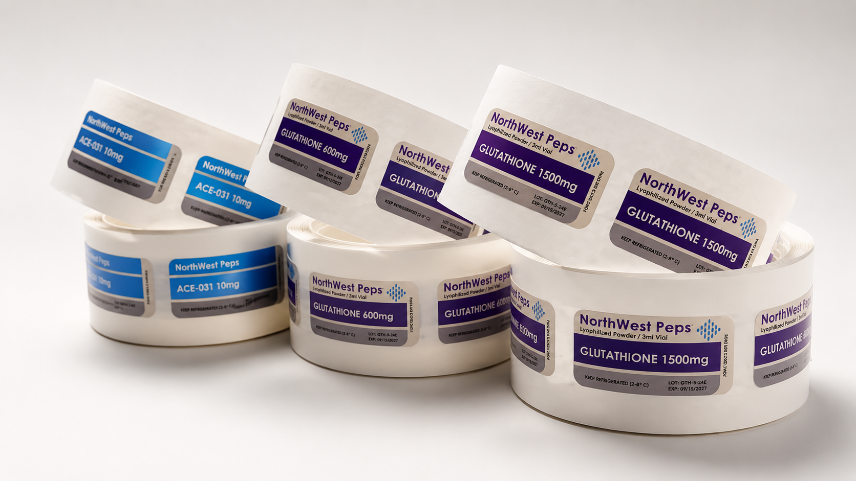 Rolls of medical labels with different medication names and dosages, some labels displayed on paper strips and others affixed to cylindrical containers.