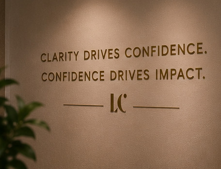 Inspirational quote on a beige wall that says, 'Clarity drives confidence. Confidence drives impact.' with a logo below.