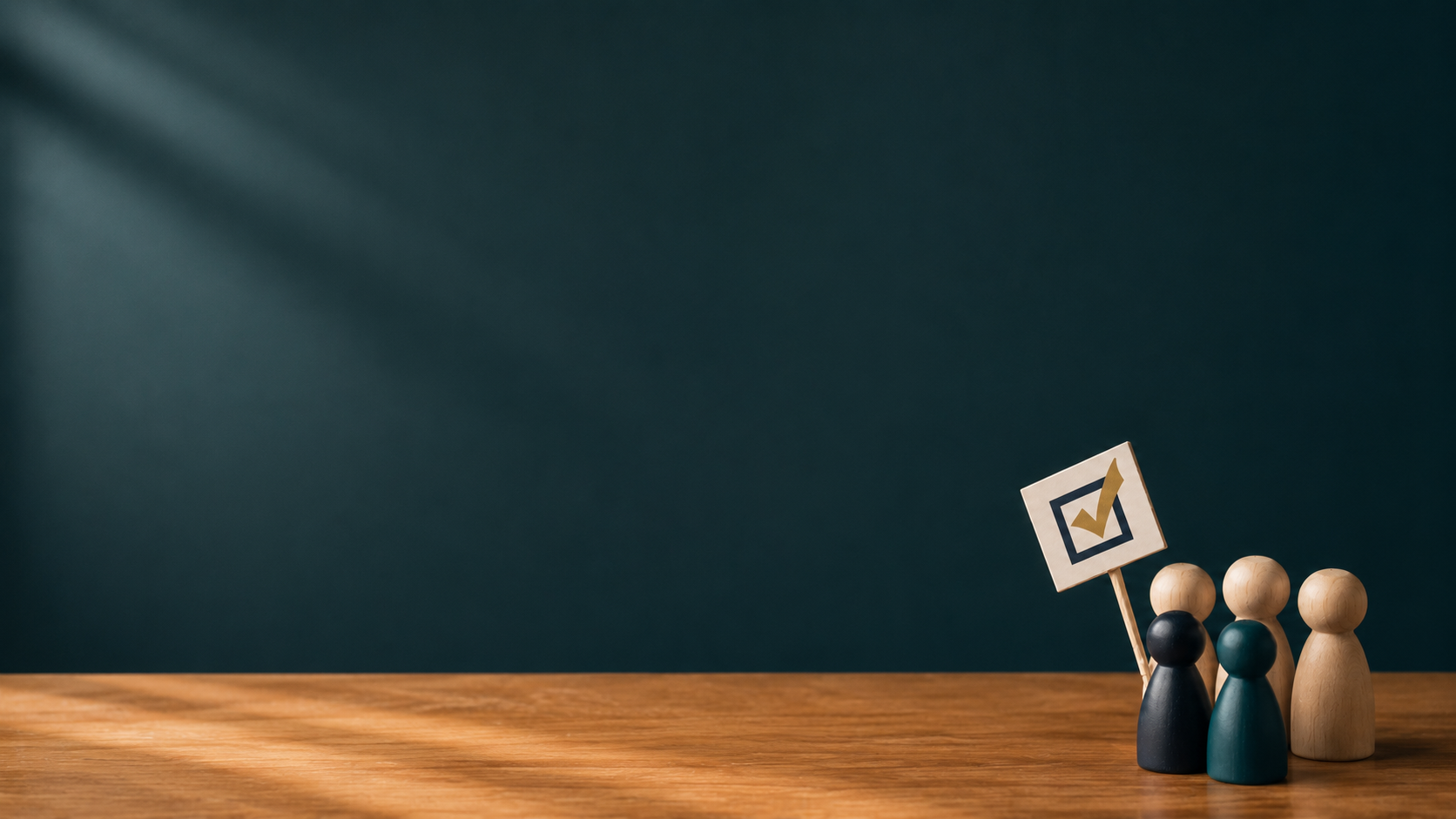 Wooden peg dolls and a small checkmark sign placed on a wooden table against a dark teal background.