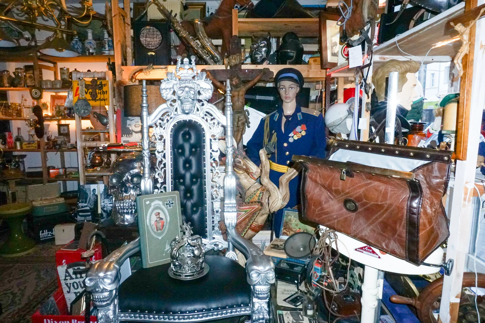 Verschiedene Antiquitäten, Skulpturen, Masken, Lampen und dekorative Gegenstände in einem Secondhand-Shop oder Antiquitätenladen.