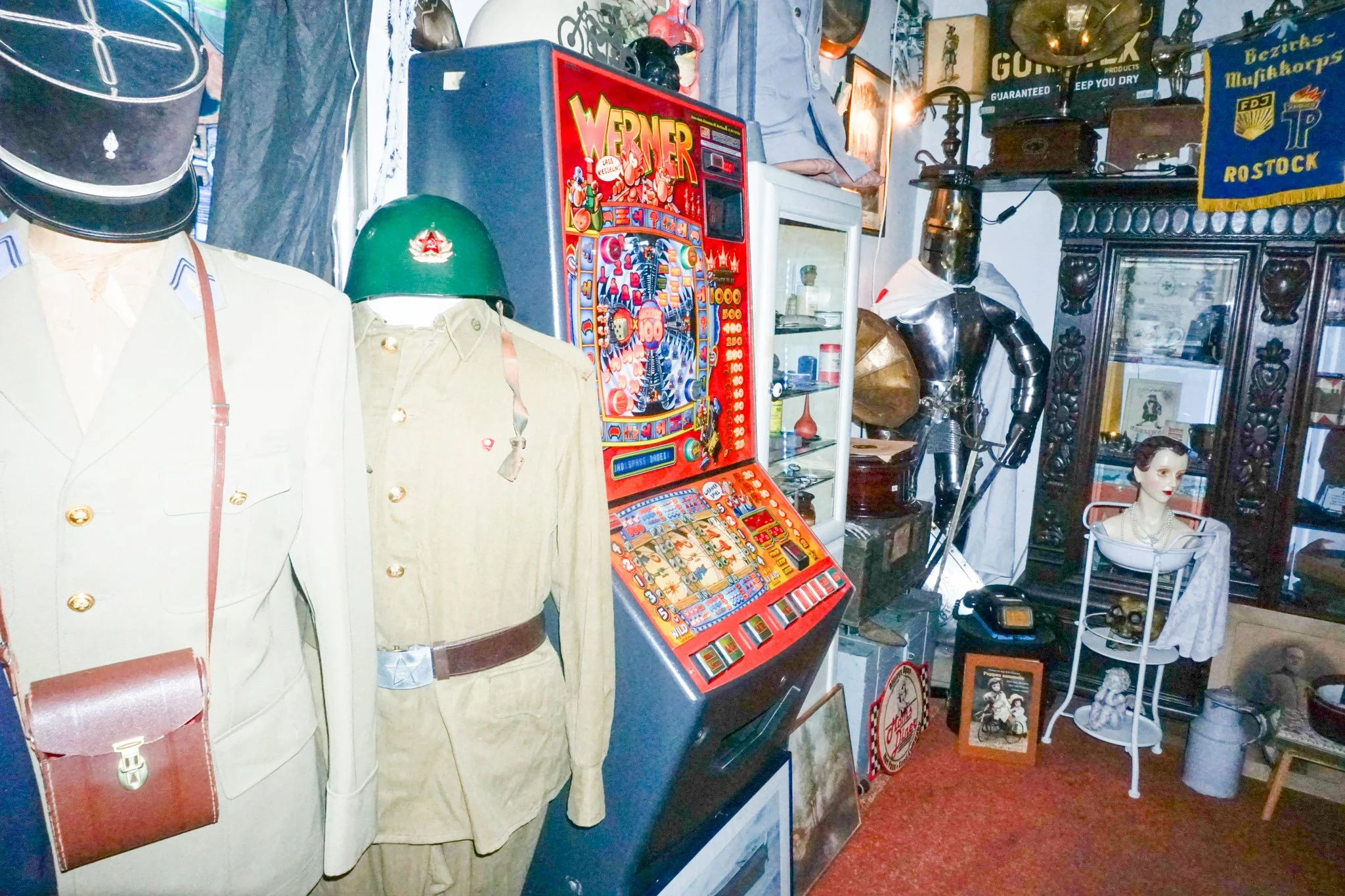 Vintage Tresor, eine alte mechanische Kaffeemühle, eine nostalgische Spielautomat und verschiedene Dekorationsgegenstände in einem Antiquitätengeschäft.