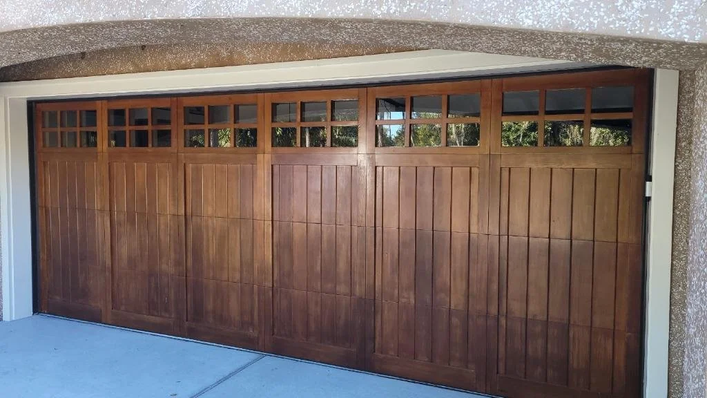 A wooden garage door with glass panels at the top