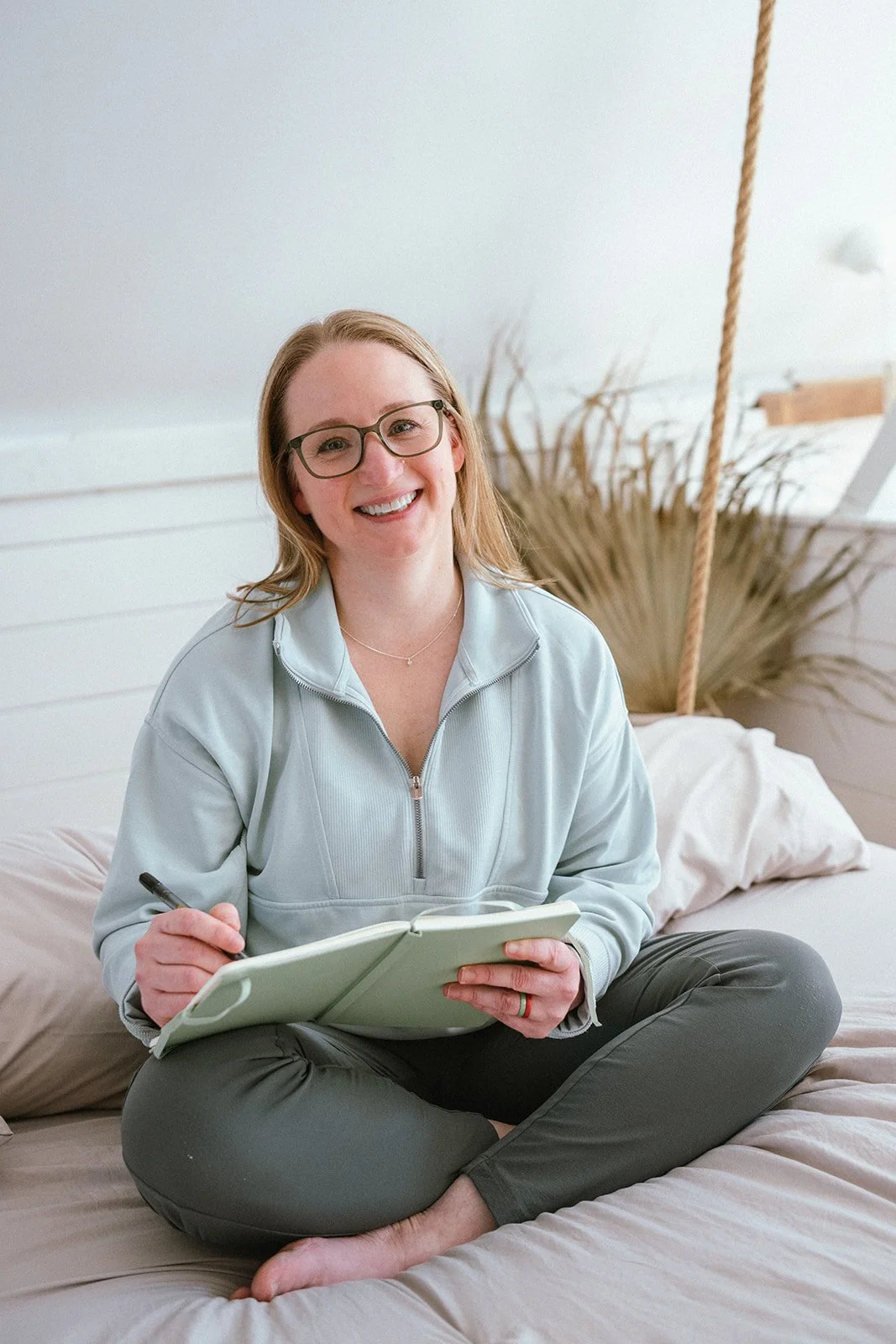 Dr Amanda sitting down and smiling while journaling and strategizing