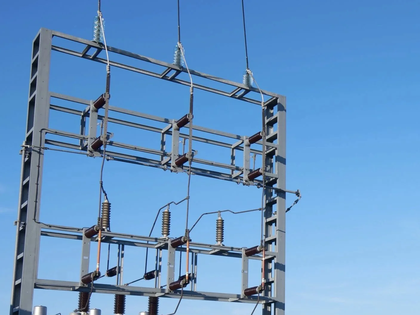 Estructura metálica de un transformador eléctrico contra un cielo azul