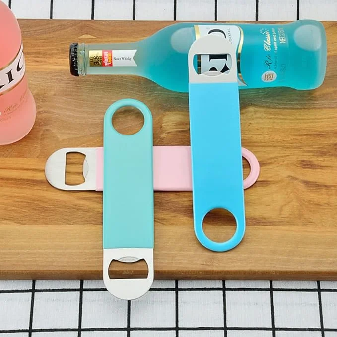 three bar keys in different colors on a wooden board with some bottles of alcohol behind  them