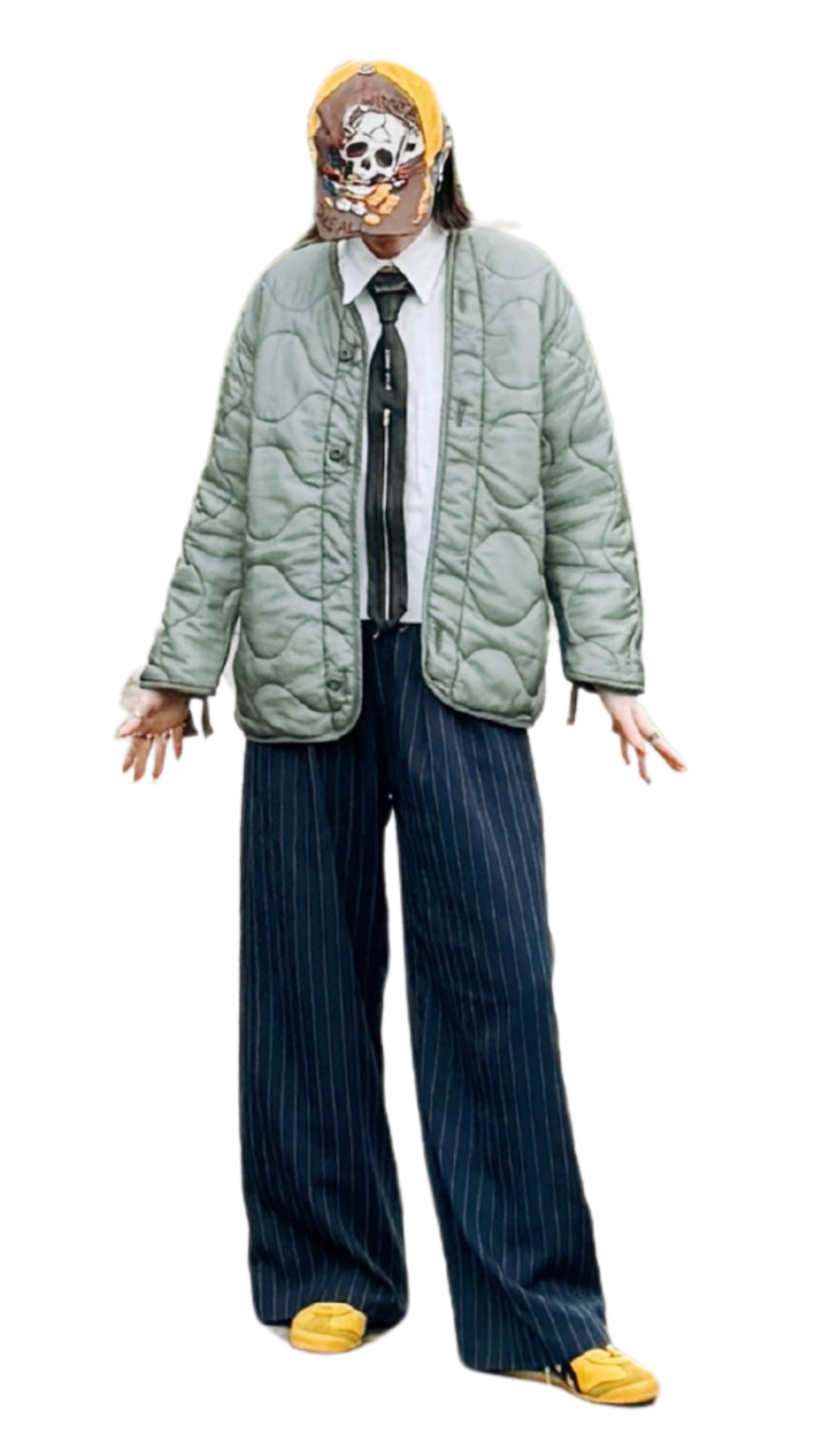 Person wearing a baseball cap with skull design, green quilted jacket, white shirt, striped wide-leg pants, and yellow shoes, standing with arms slightly open.