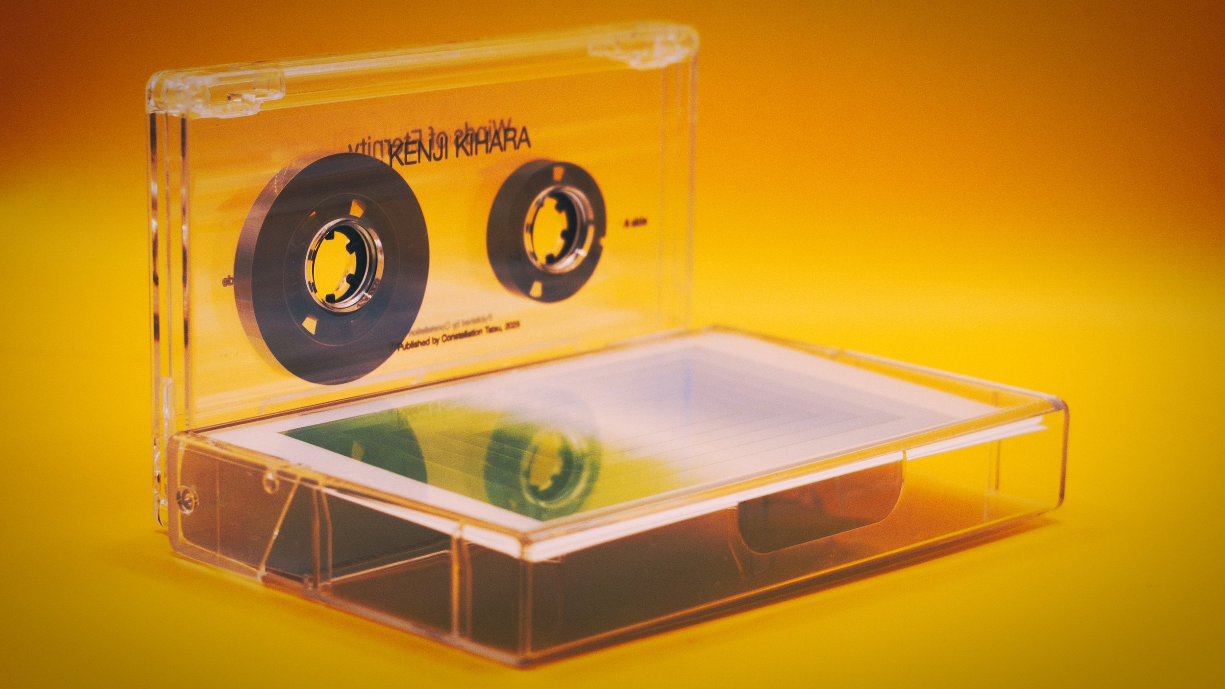 A cassette tape of Winds of Eternity by Kenji Kihara and its case arranged against a yellow background.