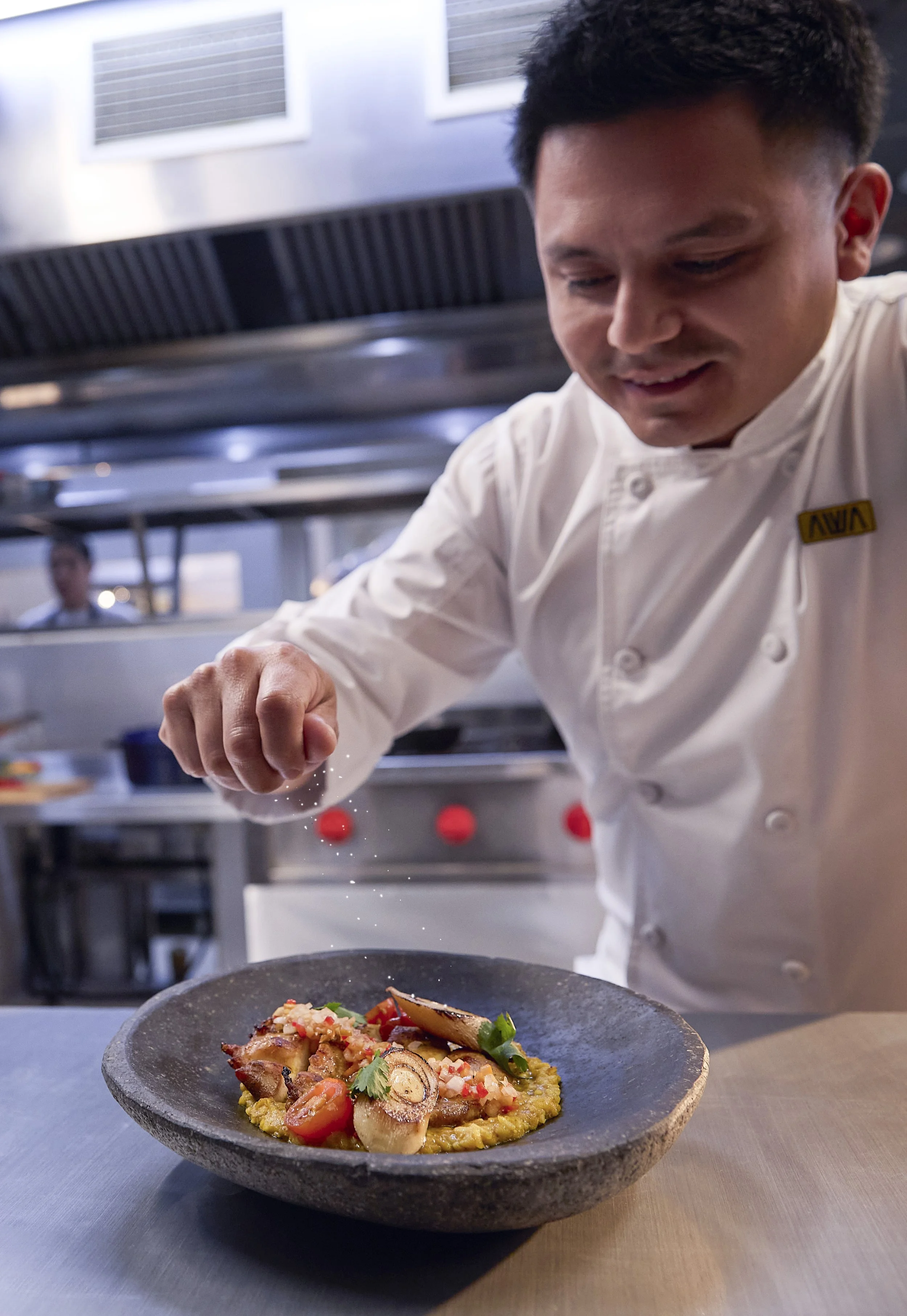 Chef decorando un plato de comida en una cocina profesional de restaurante.