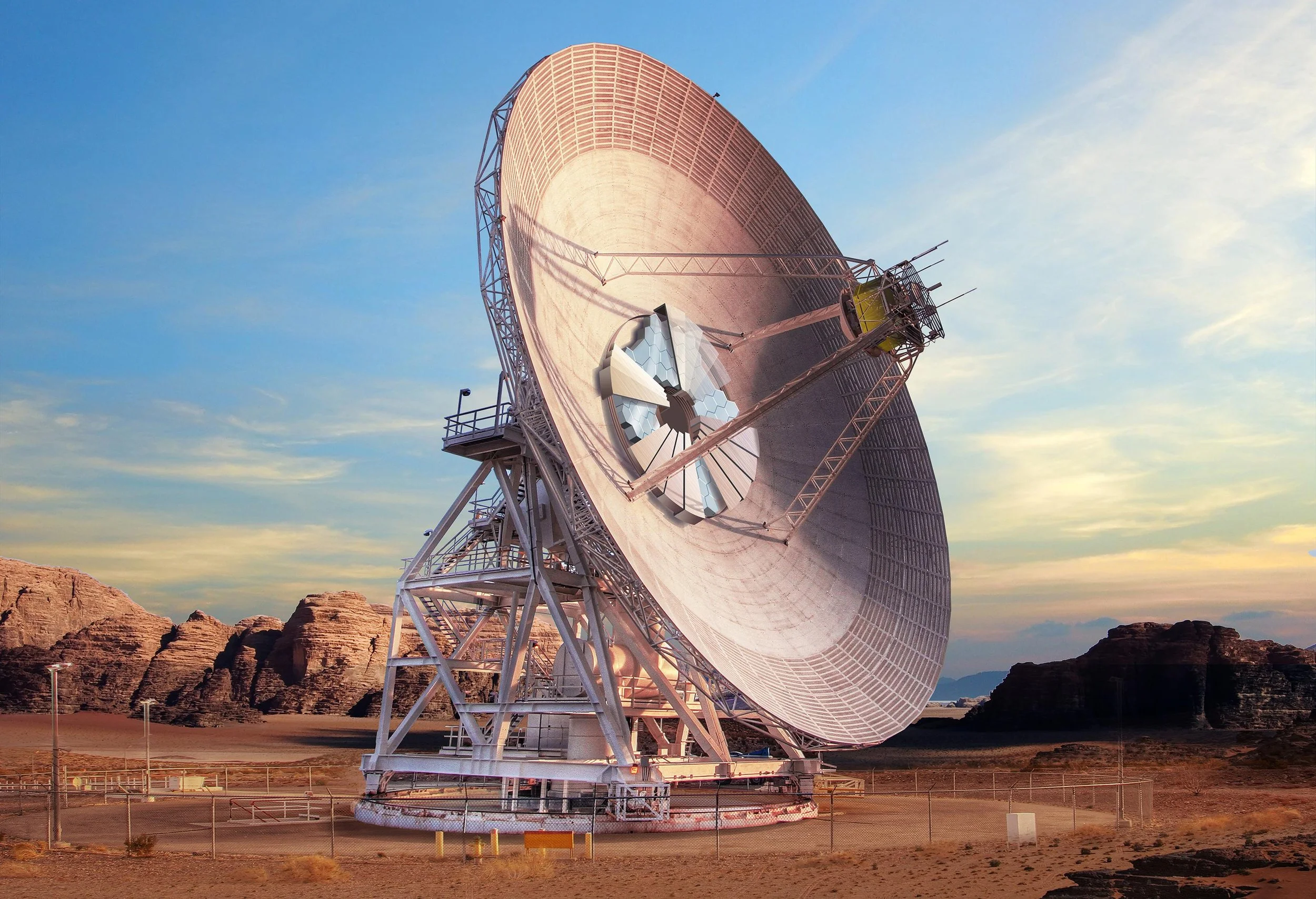 Large satellite dish in a desert landscape with rock formations, under a sky with scattered clouds during sunset.