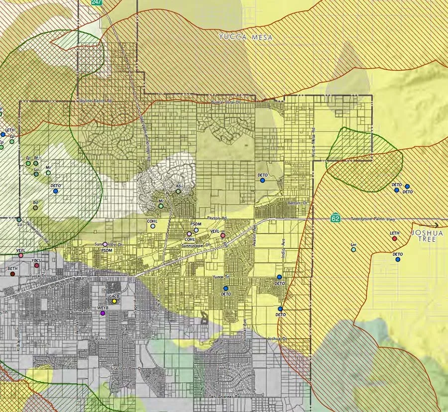 Map showing city neighborhoods, roads, and surrounding natural areas with highlighted zones and labels.