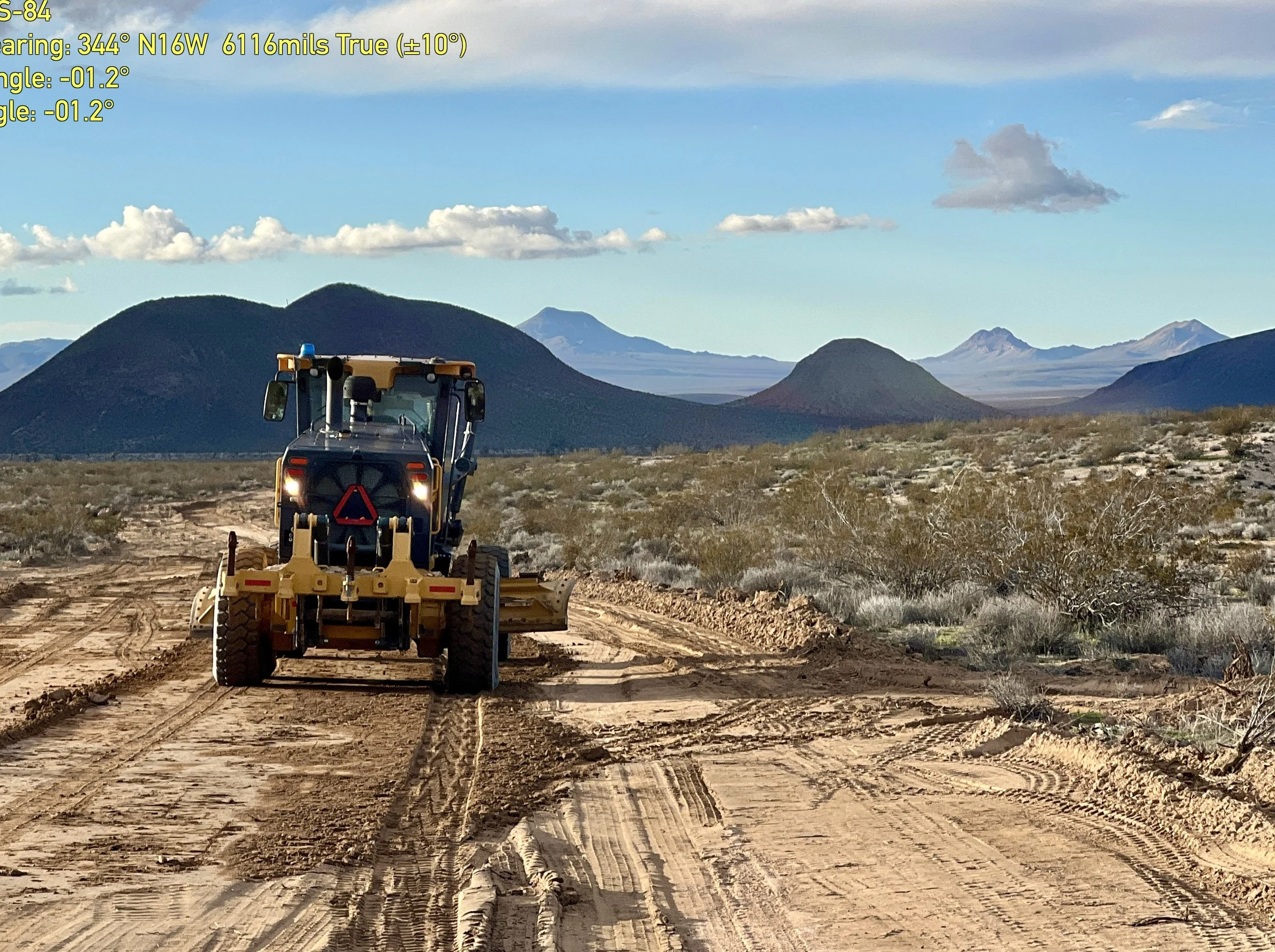 Motor grader (blade) working on a dirt road in rural desert area
