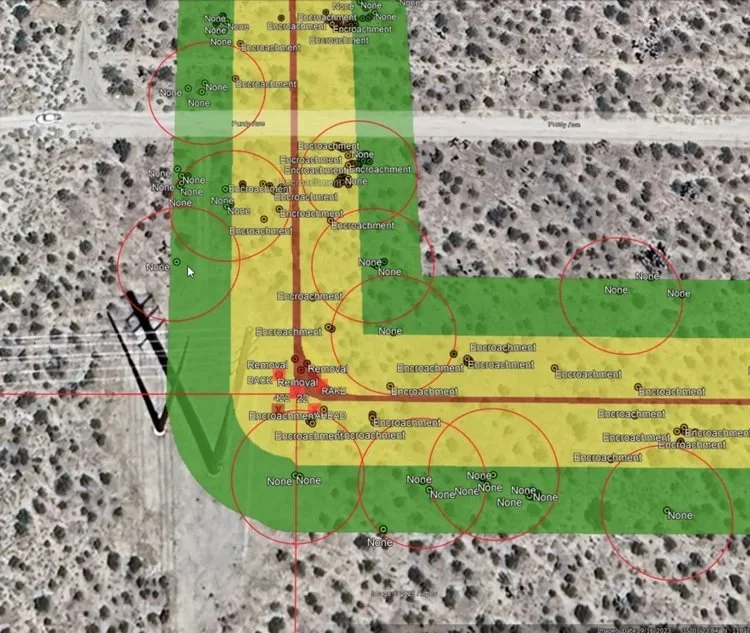 Aerial view of a desert area with various colored overlays and markings indicating zones of excavation, removal, and no activity, along with several red circles and labels such as 'None,' 'Encroachment,' and 'Removal'.