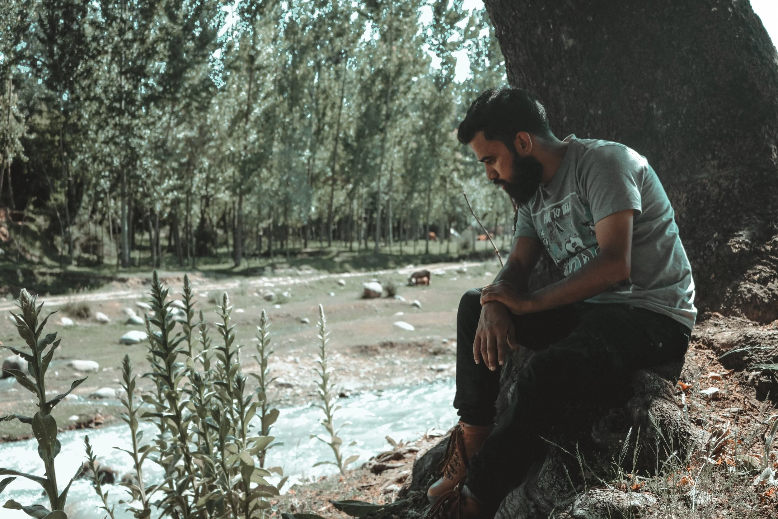 Man sitting alone by the water reflecting after difficult experiences