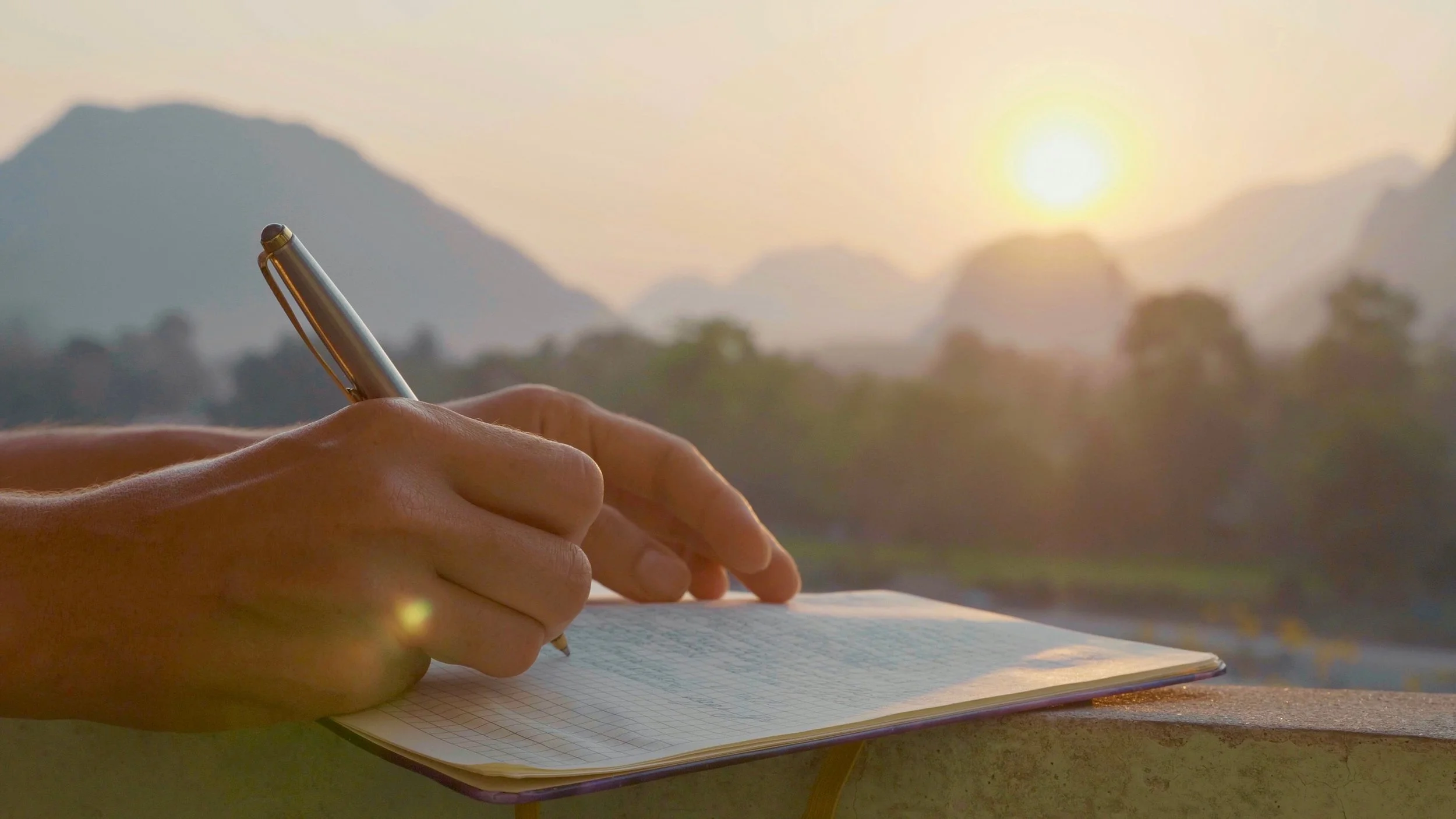 Hand writing in a journal as part of a daily reflection practice