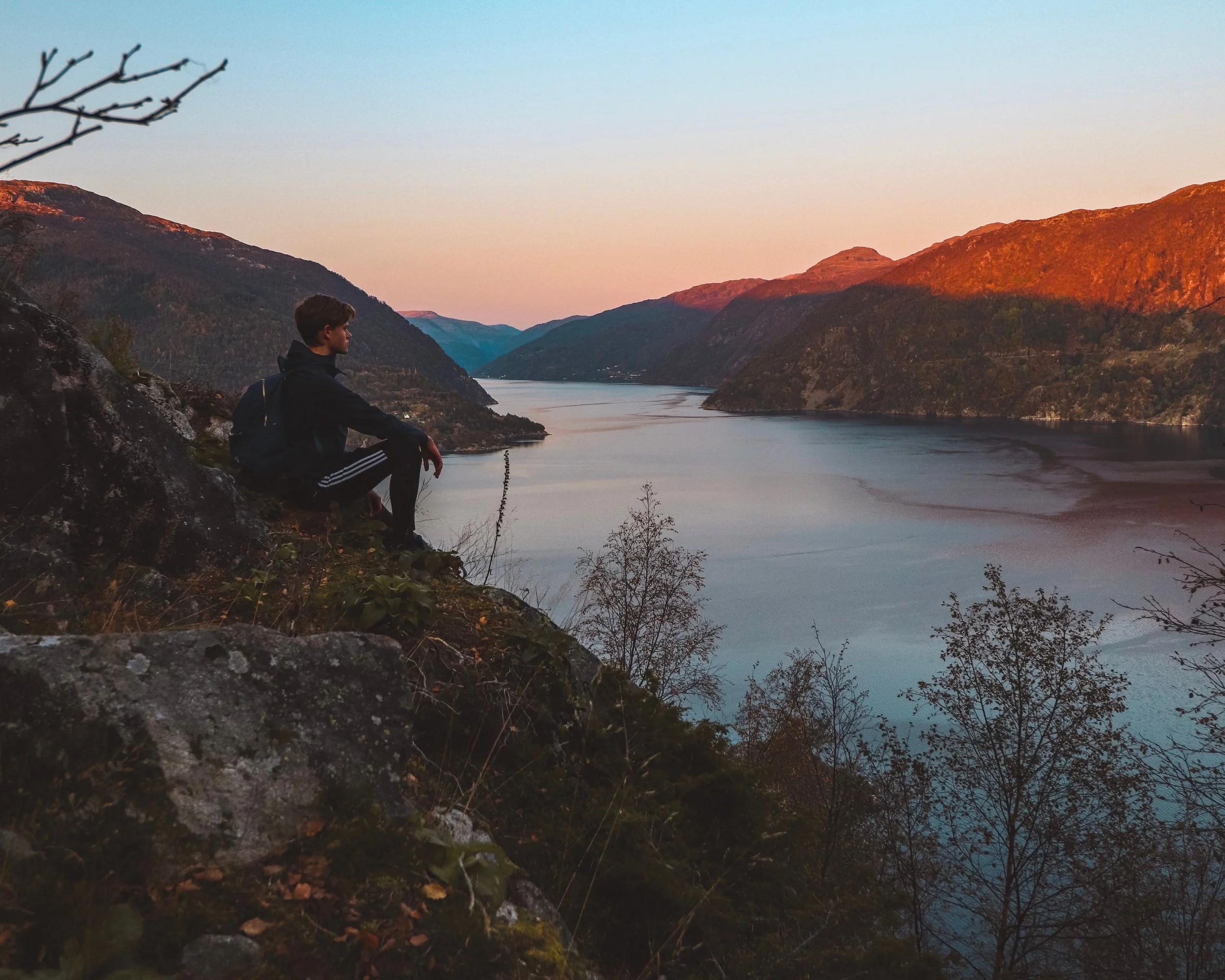 Person overlooking a peaceful mountain lake representing calm after anxiety