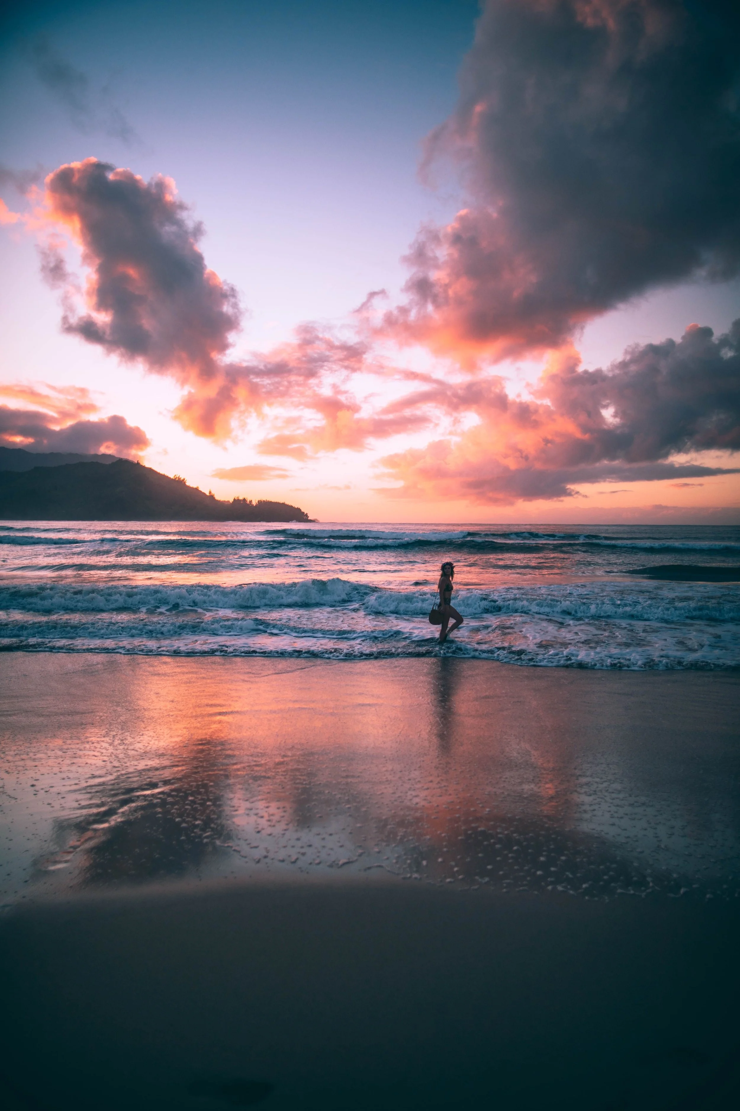 Person walking along the beach at sunset