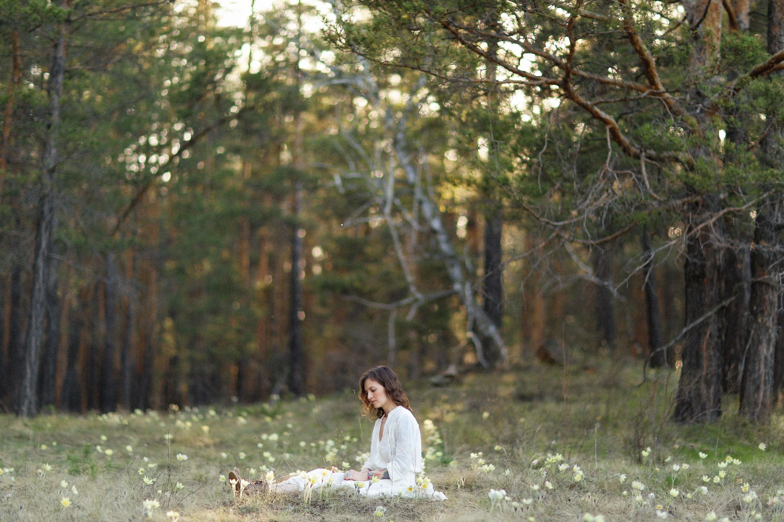 Woman sitting quietly in nature reflecting while experiencing anxiety