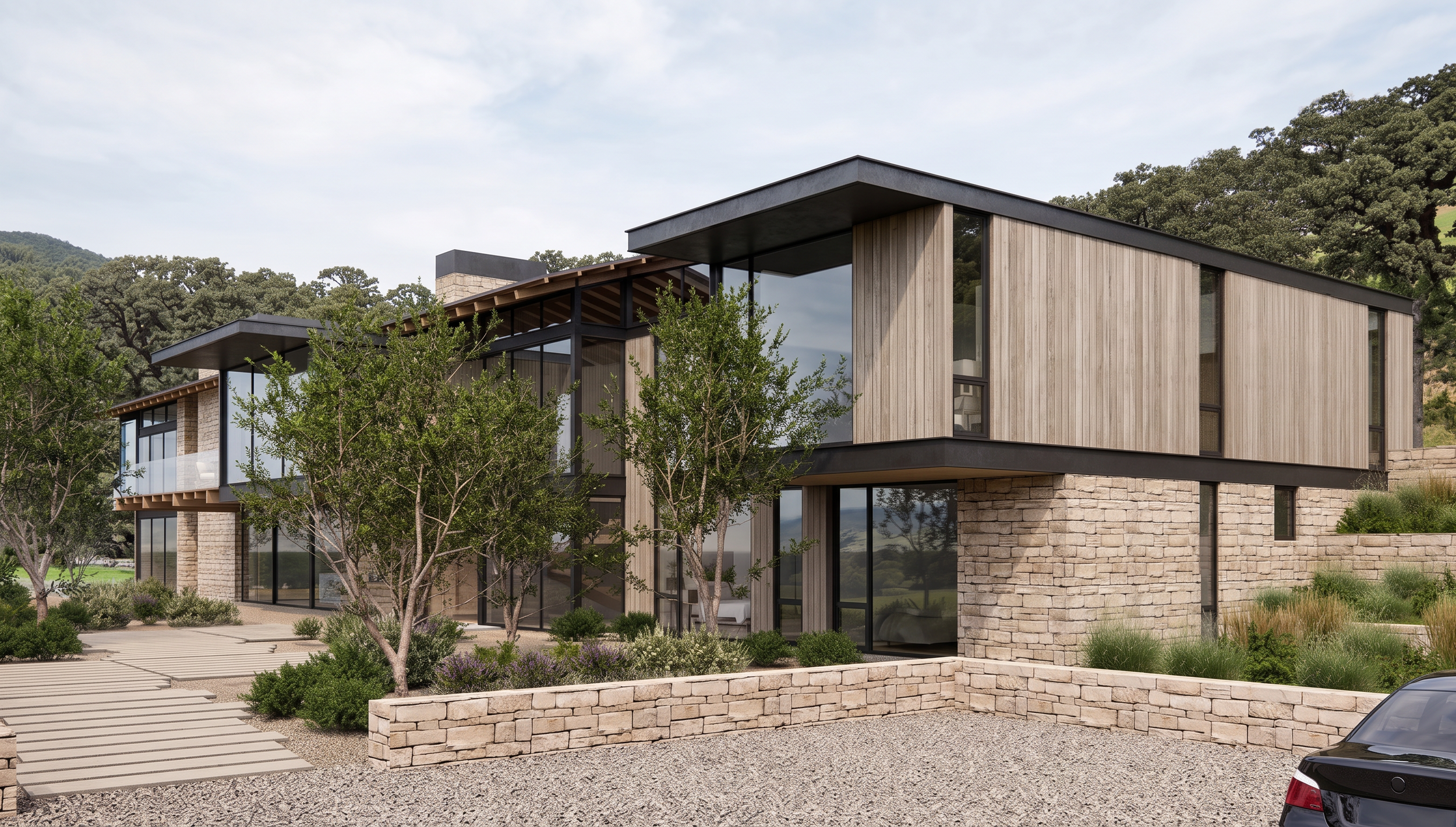 Modern residential building with wooden and stone exterior, large glass windows, surrounded by trees, with a gravel driveway and parking area in the front.