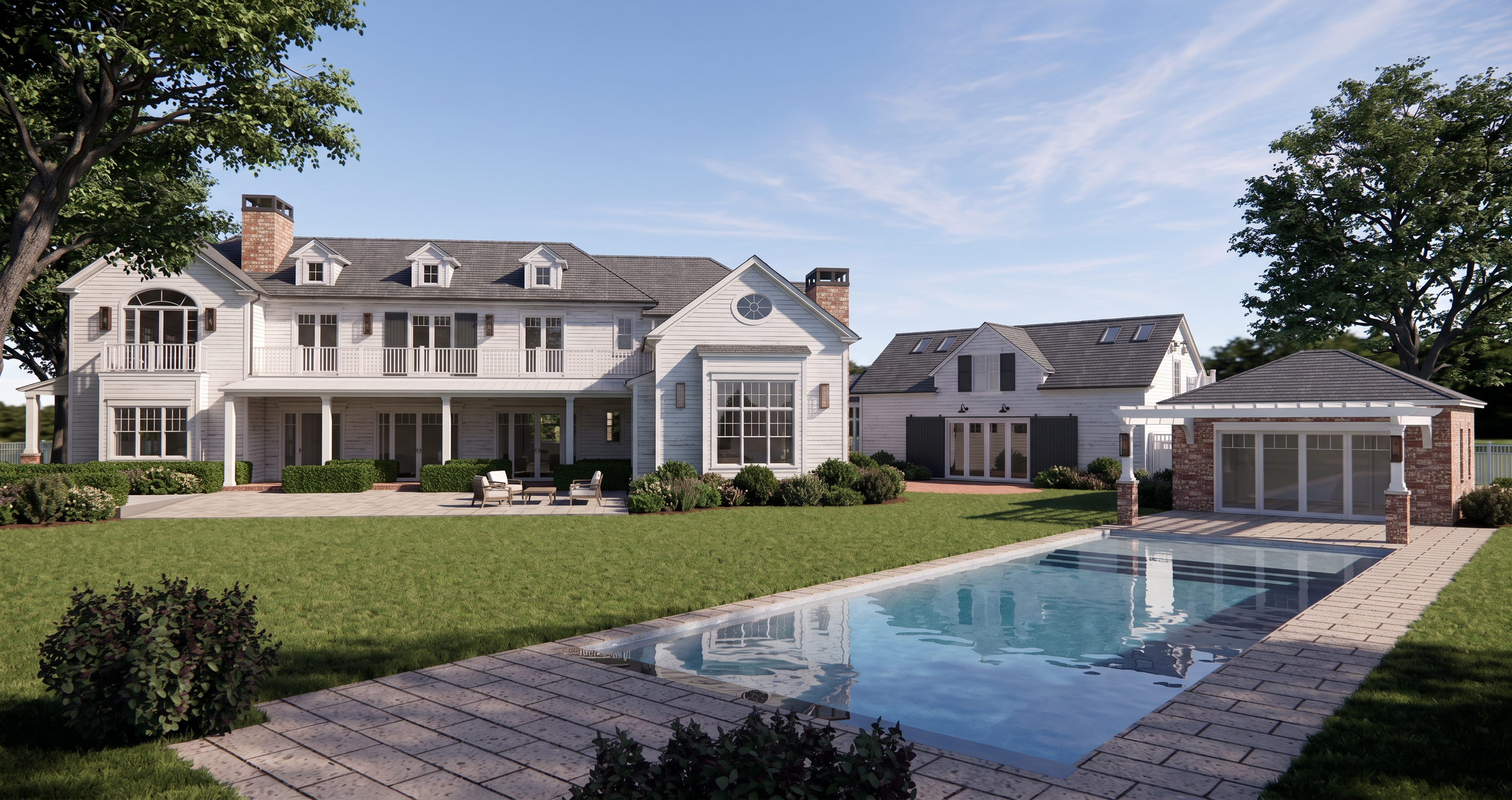 A large white house with multiple windows and a backyard with a swimming pool, patio furniture, and landscaped bushes under a blue sky with clouds.