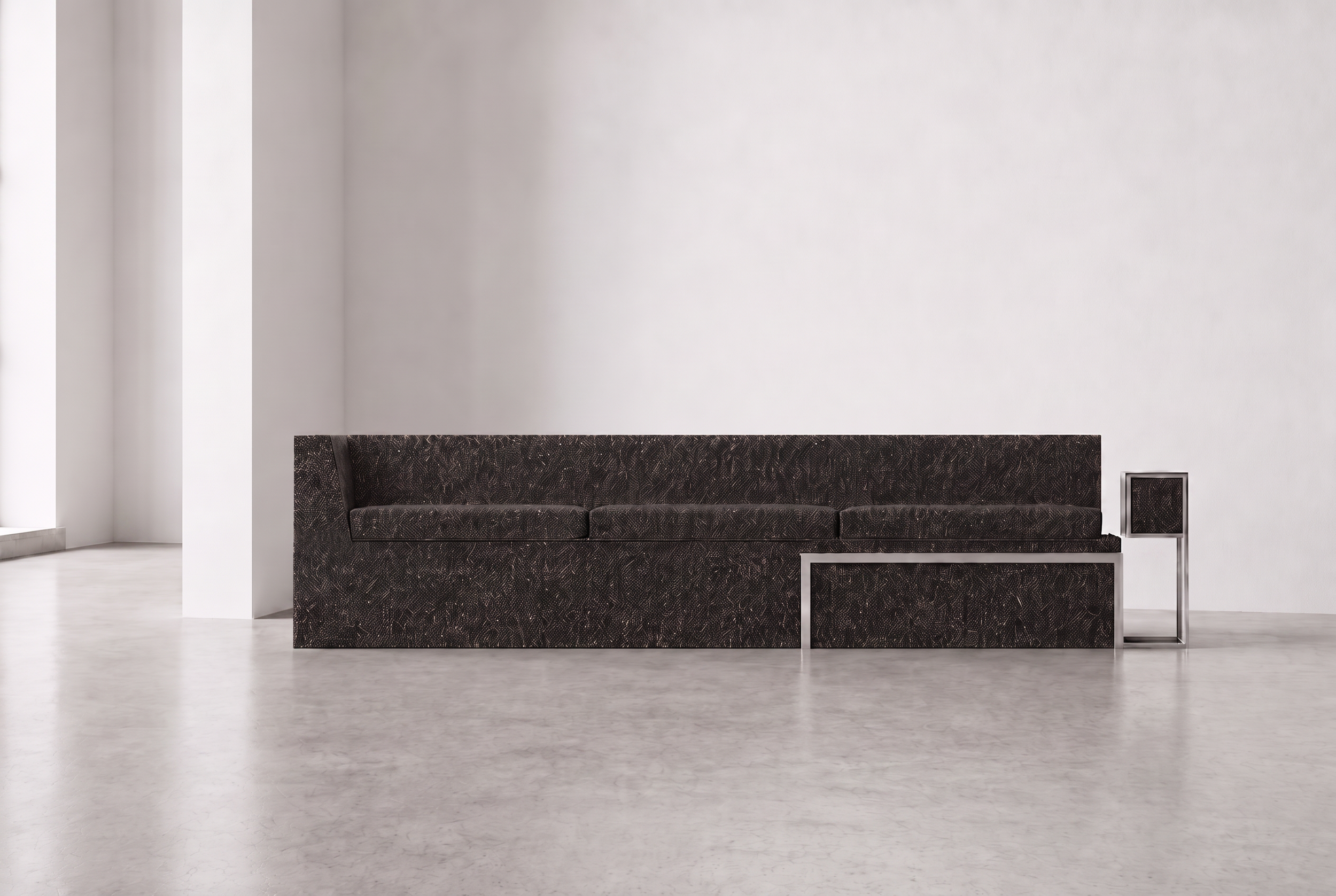 Minimalist interior with a dark brown textured sofa, a modern black and metal side table, white walls, and light gray flooring.