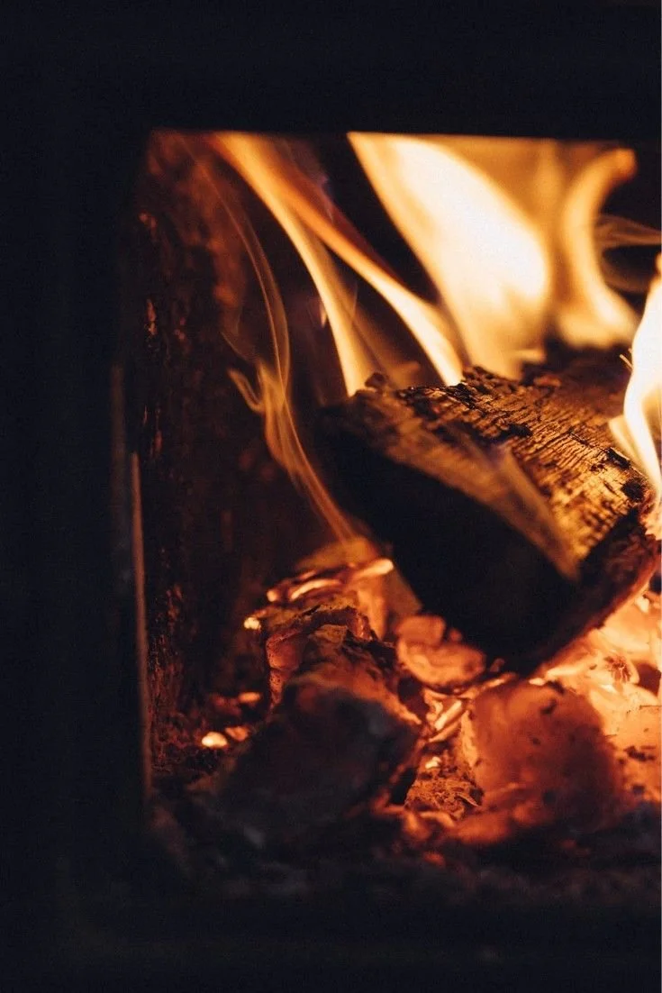 Close-up of burning logs and glowing embers in a fireplace