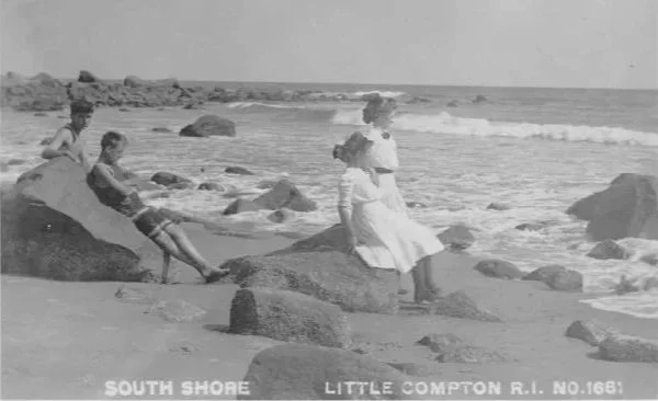 Vintage black-and-white postcard showing people relaxing on rocks at South Shore beach in Little Compton, Rhode Island.