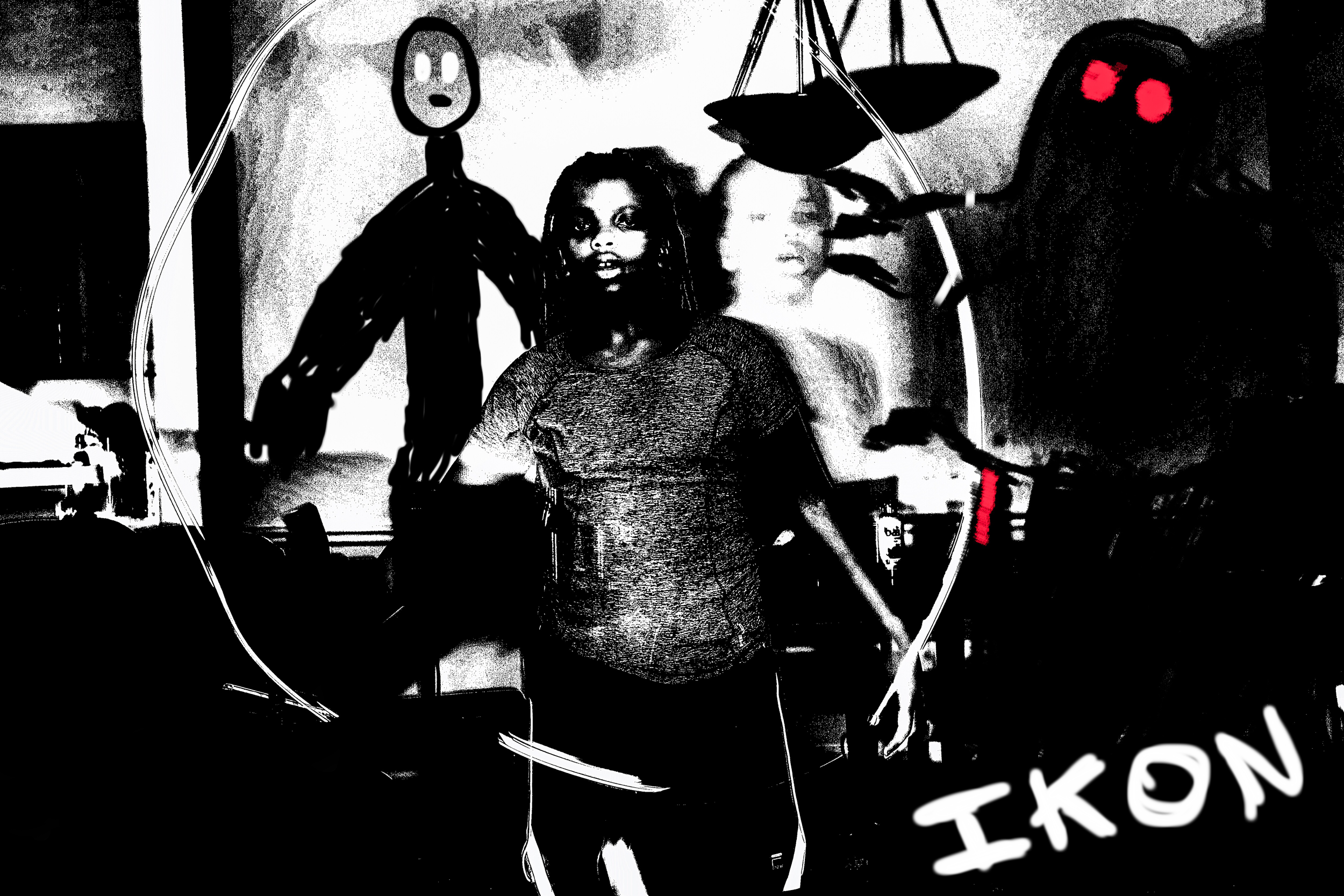A person with long dreadlocks standing behind a plexiglass barrier, with a black and red robot head to their right and another person blurred in the background. The setting appears to be an indoor space, possibly at a science or technology event.