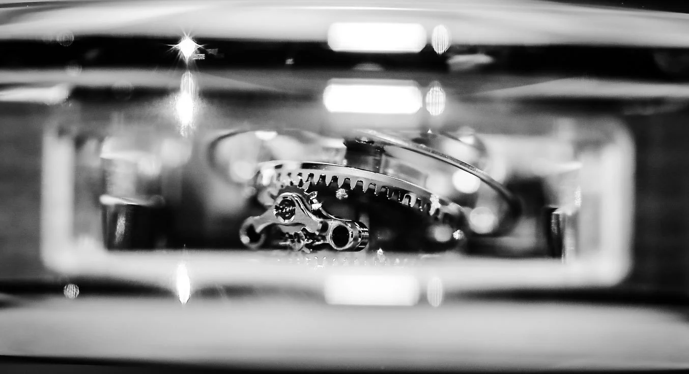 Close-up of watch gears and mechanisms captured in black and white.