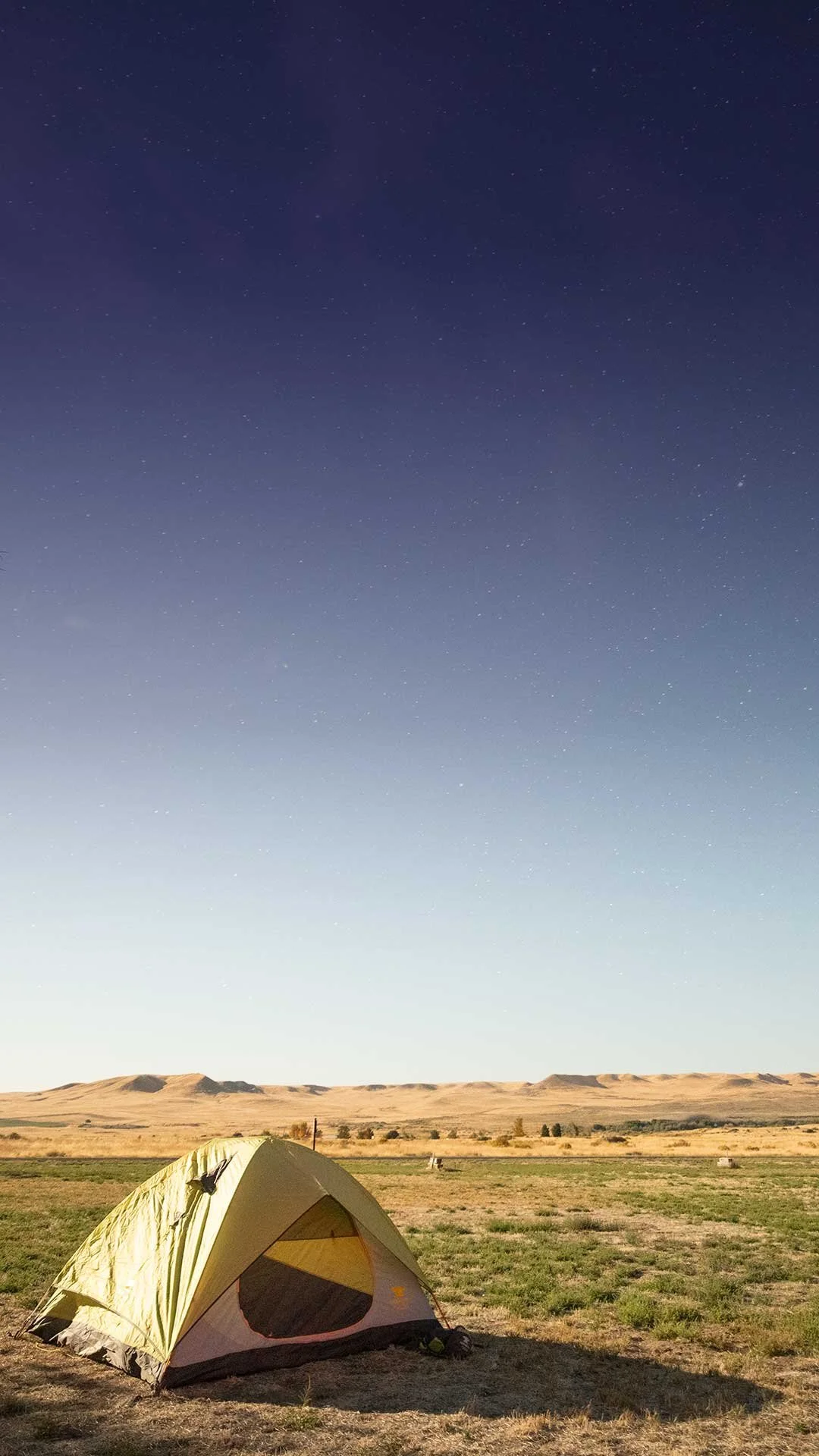Tent in an open desert landscape under the stars