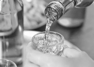 Alcohol — a glass of ice and liquid being poured