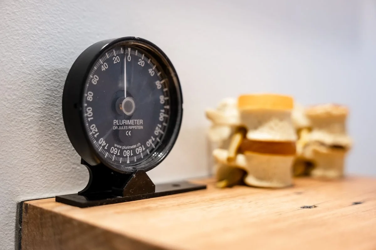 A black kitchen timer on a wooden surface next to a pile of sliced bread rolls.