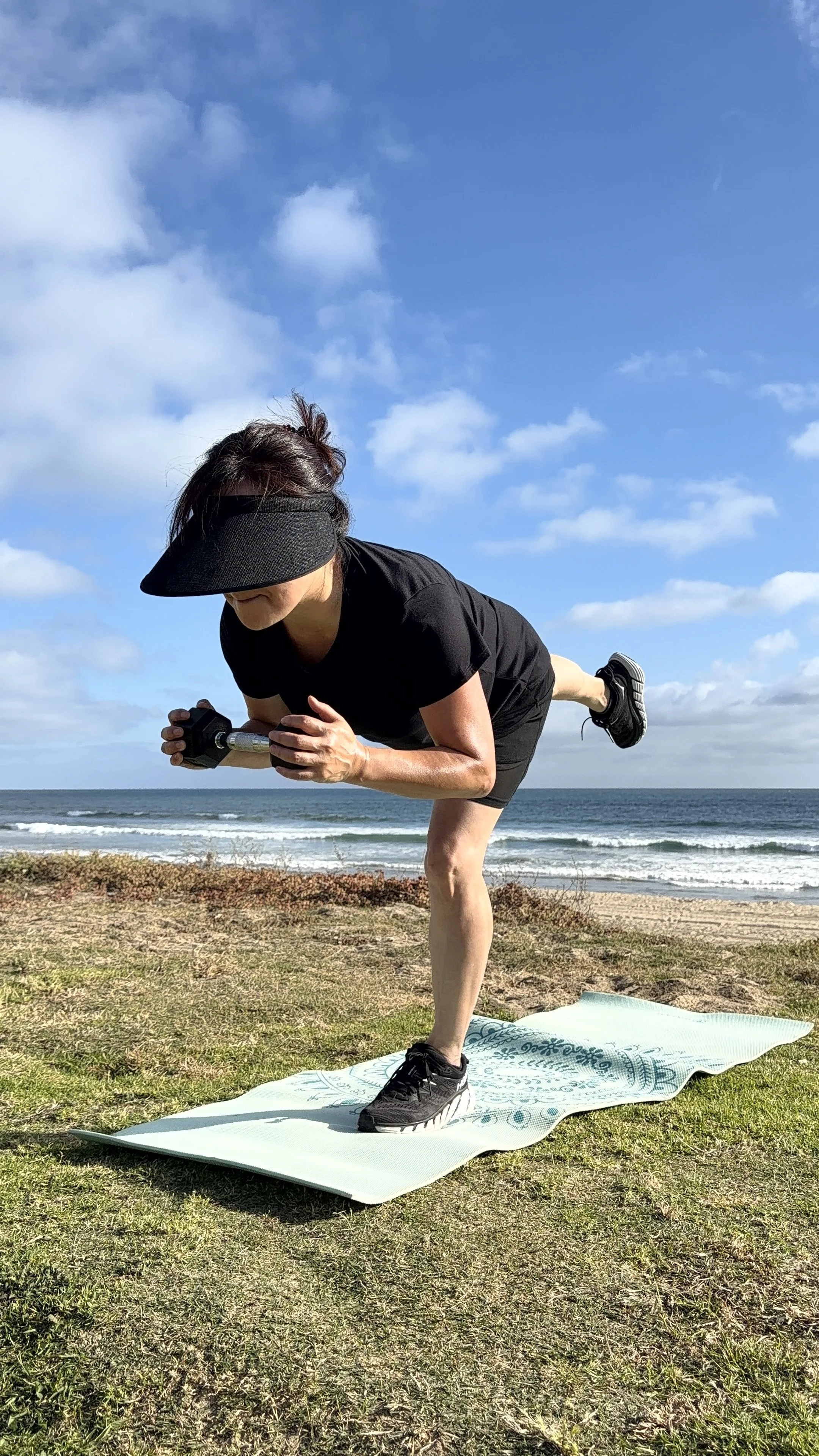 Woman performing a dumbbell workout outdoors in Ocean Beach, San Diego.