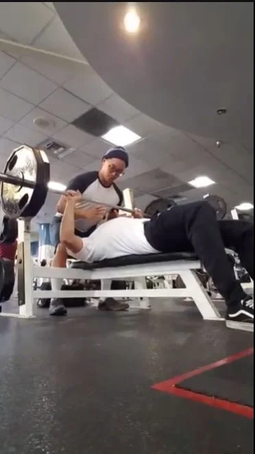 Personal trainer spotting a client during a bench press in La Mesa, San Diego.
