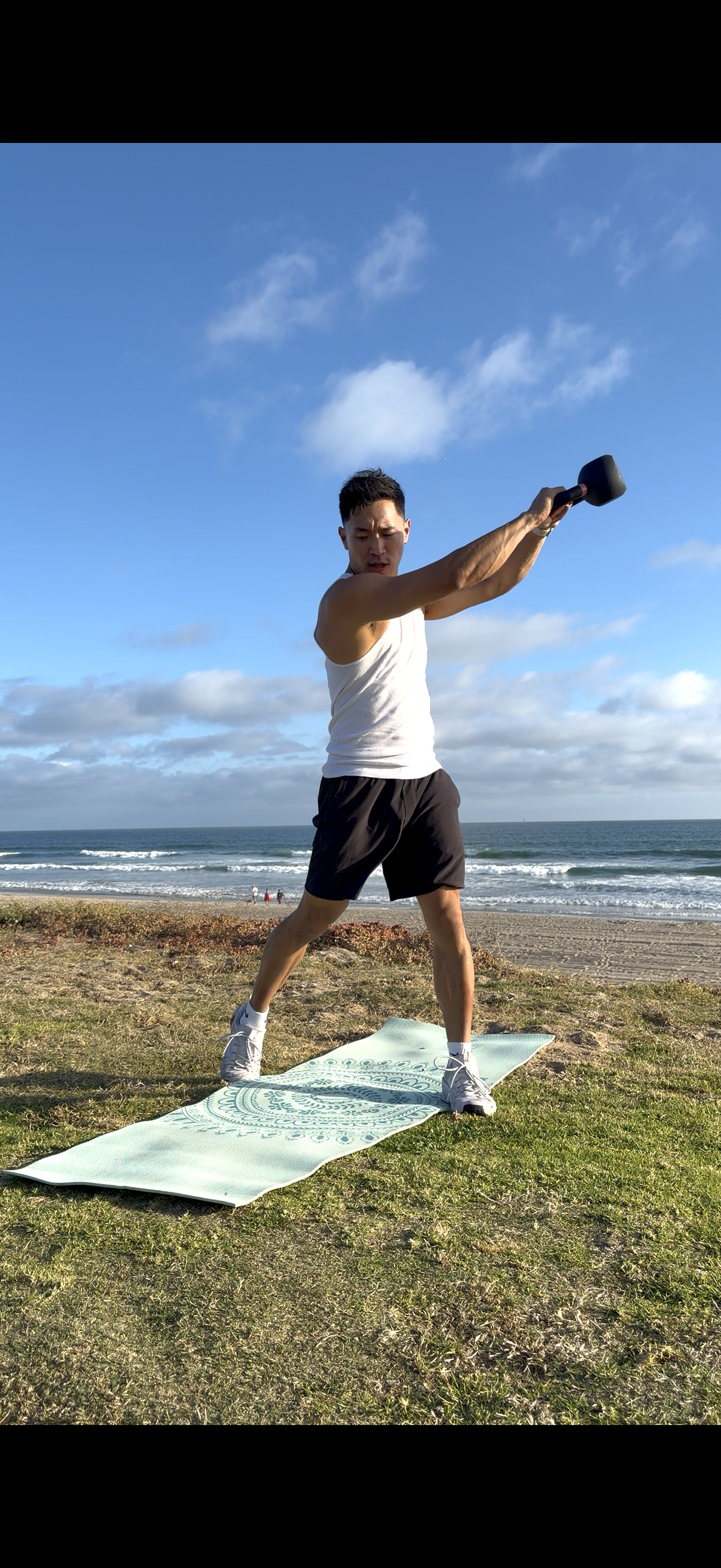 Man performing a strength exercise outdoors in Ocean Beach, San Diego.