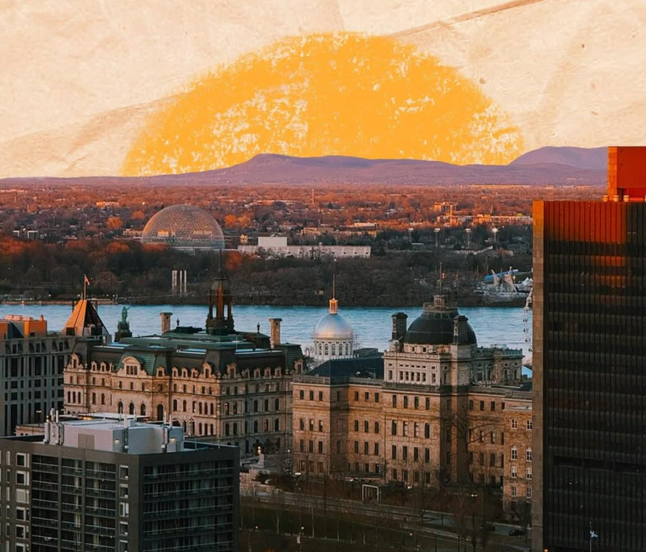 City skyline with historic buildings, of which some have domes and spires, across a river with a small dock and a large modern black building on the right, with the distant mountains and orange sunset sky in the background.