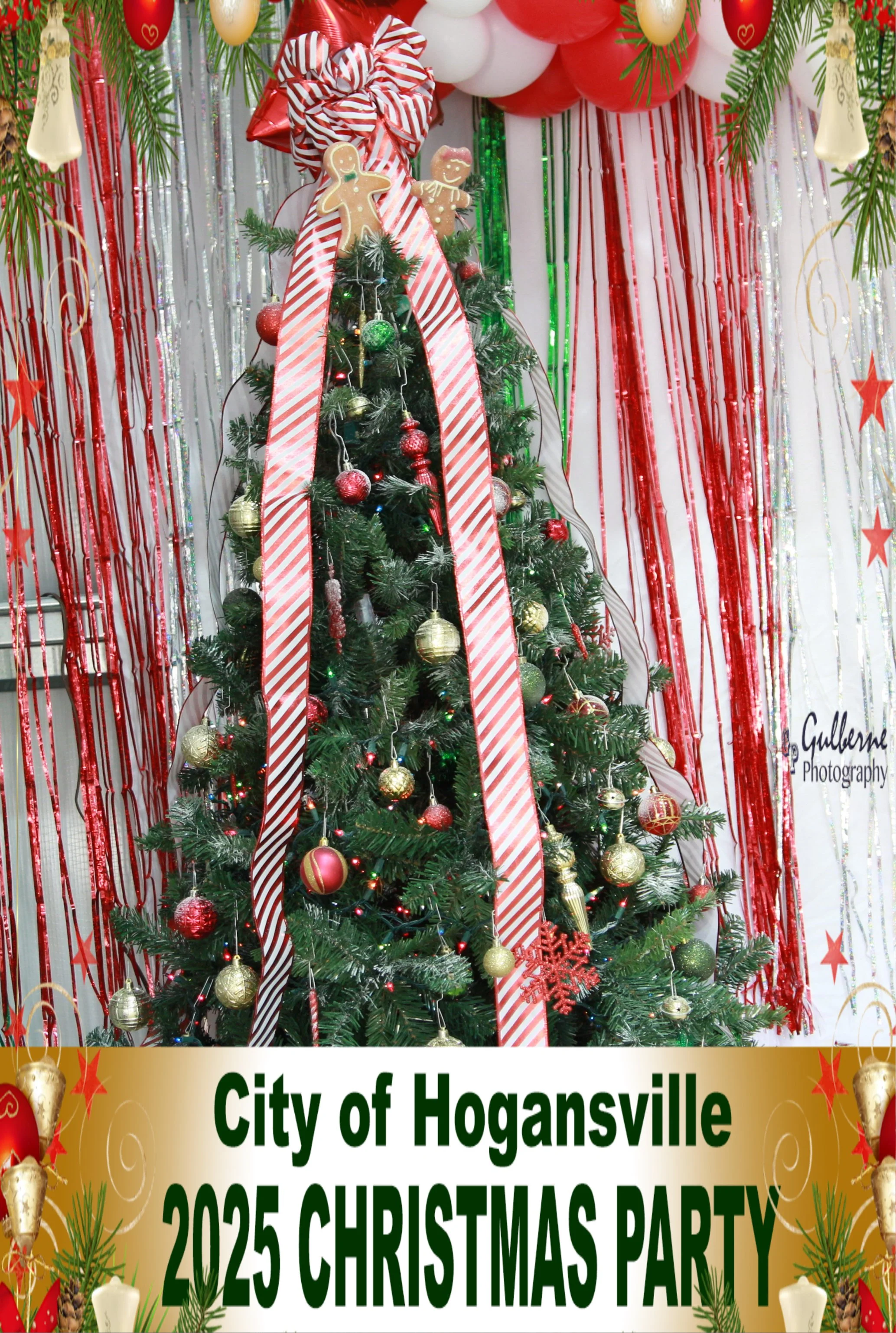 Decorated Christmas tree with red and gold ornaments, gingerbread cookies, red and white striped ribbons, and surrounded by festive decorations including red balloons, jute ornaments, and green garland. There are silver and gold streamers background,